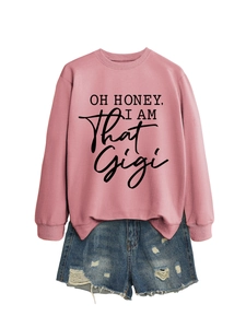 Detail of pink crewneck sweatshirt with black text print and distressed denim shorts