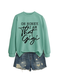 Detail of mint green sweatshirt with 'Oh Honey' print and distressed denim shorts