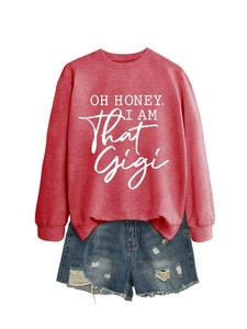 Detail of red crewneck sweatshirt with white text and distressed blue denim shorts