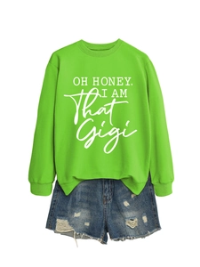 Detail of lime green sweatshirt with white graphic print paired with distressed denim shorts