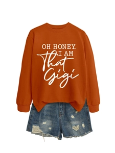 Detail view of orange graphic sweatshirt with OH HONEY text and distressed denim shorts