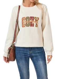 Detalle de la sudadera cozy season con letras en cuadros y estampado de leopardo