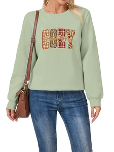 Detalle de la sudadera verde salvia Cozy Season con estampados de cuadros y leopardo