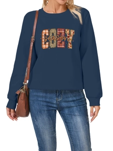 Detalle de sudadera azul marino con parche 'COZY season', cuadros y estampado de leopardo