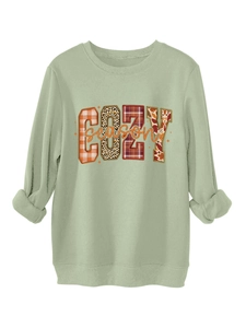 Primer plano del estampado COZY season con cuadros y leopardo en sudadera verde claro