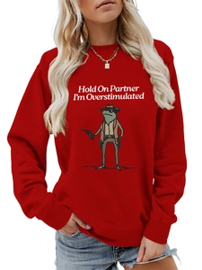 Detail of red crewneck sweatshirt featuring a funny cowboy frog graphic and slogan