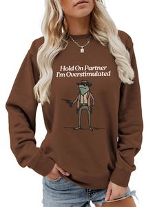 Detail of the cowboy frog print on a brown oversized long-sleeve crewneck sweatshirt