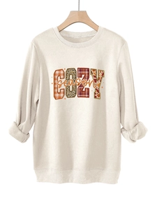 Detalle del estampado COZY season con patrón de leopardo y cuadros en sudadera felpa
