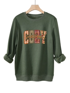 Detalle del estampado COZY season en sudadera verde oscuro con motivos de cuadros