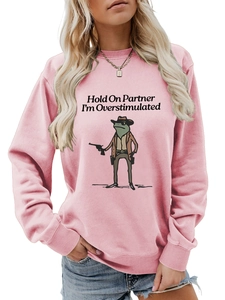 Detail of pink sweatshirt featuring text and a frog in cowboy outfit print design