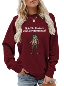 Close-up of burgundy sweatshirt featuring a cowboy frog print and humorous text design