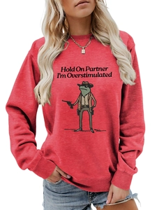 Detail of red crewneck sweatshirt featuring a funny cowboy frog graphic and slogan