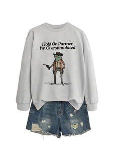 Detail of grey sweatshirt with cowboy frog print and distressed blue denim shorts