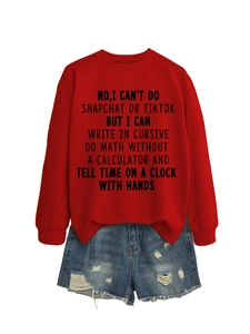 Flat lay of a red crewneck sweatshirt with black slogan print and ripped denim shorts