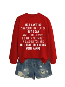 Flat lay of red sweatshirt with white text slogan paired with distressed denim shorts
