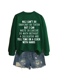 Detail of green crewneck sweatshirt with white text print and distressed denim shorts
