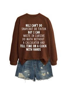 Detail of a brown crewneck sweatshirt featuring white humor text and distressed denim shorts