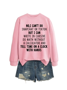 Detailed view of pink sweatshirt with black slogan print paired with denim shorts