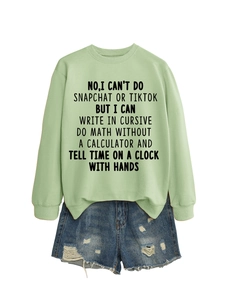 Detail view of mint green sweatshirt with fun letter print paired with denim shorts