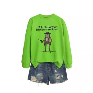 Neon green sweatshirt with cowboy frog print and blue ripped denim shorts layout