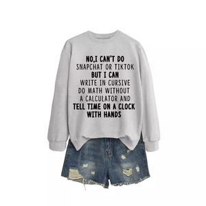 Gray crewneck sweatshirt with slogan print paired with distressed denim shorts