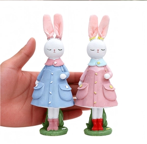 Primo piano dettagliato di figurine di coniglietti pasquali in resina colorata in mano