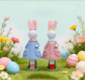 Dettaglio di figurine di coniglietto pasquale in resina con abiti floreali e uova