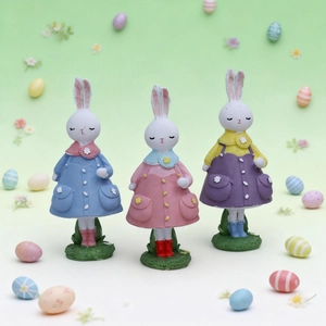 Three colorful resin Easter bunny figurines in skirts on grass bases for home decor