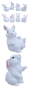 Macro detail of eight miniature white resin bunnies showing realistic fur texture and features