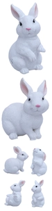 Detail view of four miniature white resin bunnies with realistic fur texture and pink ears