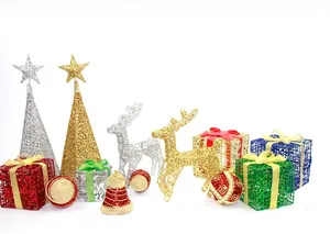 Macro shot of silver and gold glittered reindeer with metal cone trees and gift boxes