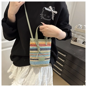 Detail der bunt gestreiften Stroh-Handytasche mit Modeschild und Schultergurt