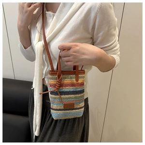 Detail einer bunten geflochtenen Handytasche mit braunem Lederbesatz und Patch