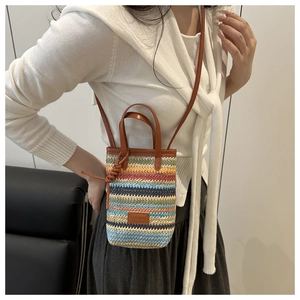 Detail shot of the colorful woven crossbody phone bag with fashion leather label and strap