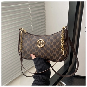 Close-up of monogram pattern hobo bag with gold M logo and metallic chain strap detail