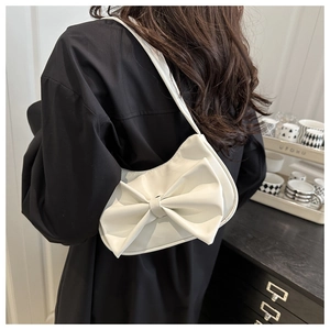 Elegant white PU leather bag with bow decoration shown on a model in a modern interior