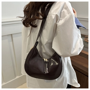 Detailed back view of dark brown crescent hobo bag with gold zippers and long pull tabs