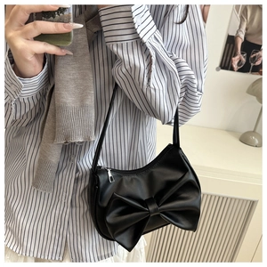 Detail shot of the black Y2K shoulder bag with a large decorative bow and silver zipper