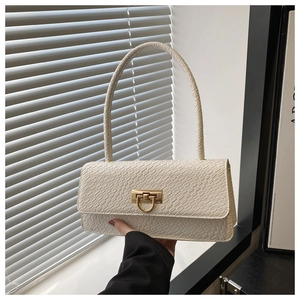 Detailed close-up of white crocodile pattern baguette bag with golden horseshoe buckle