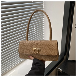 Detail of khaki baguette bag featuring crocodile pattern and gold metal clasp closure