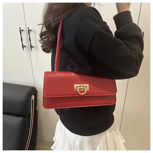 Detail of red croc-embossed baguette bag with a premium gold-tone metal twist lock