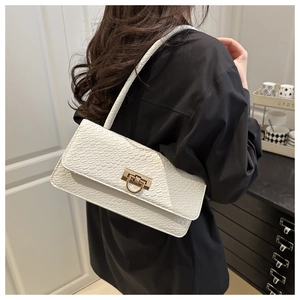 Close-up of white baguette bag featuring crocodile pattern texture and golden metal buckle