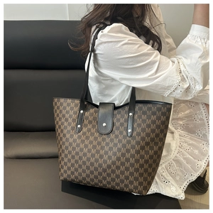 Close-up detail of the brown tote bag featuring all-over M-pattern and magnetic closure