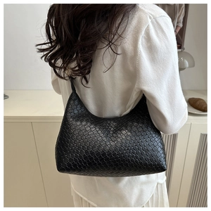 Detailed view of black woven hobo shoulder bag styled in a cozy minimalist interior