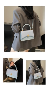 Detail view of light blue textured leather handbag with a gold square clasp and round handle
