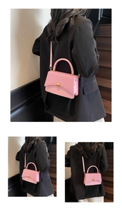 Detail view of pink crossbody bag showing fine leather texture and golden metal square lock