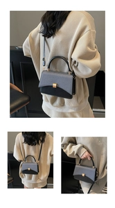 Detail of color-block saddle bag featuring pebbled leather and golden metal clasp