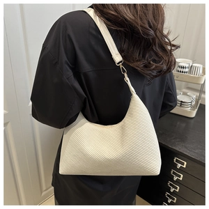 Detail of white woven texture on leather hobo bag with golden metal hook hardware