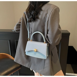 Détail du sac à bandoulière bleu clair avec rabat texturé et fermoir métallique élégant