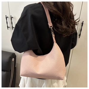 Detail showing pink hobo bag with woven texture and gold metal buckle on shoulder